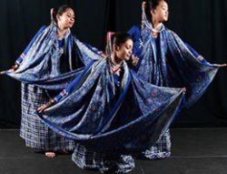 Three women dancers wearing blue garments.